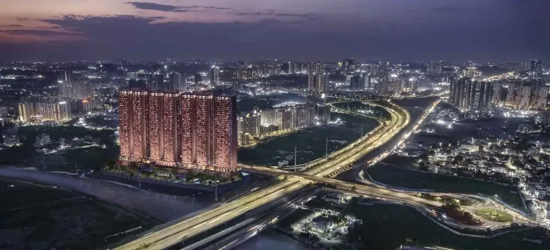 Night aerial of a Sri Aditya Homes project beside a Hyderabad expressway
