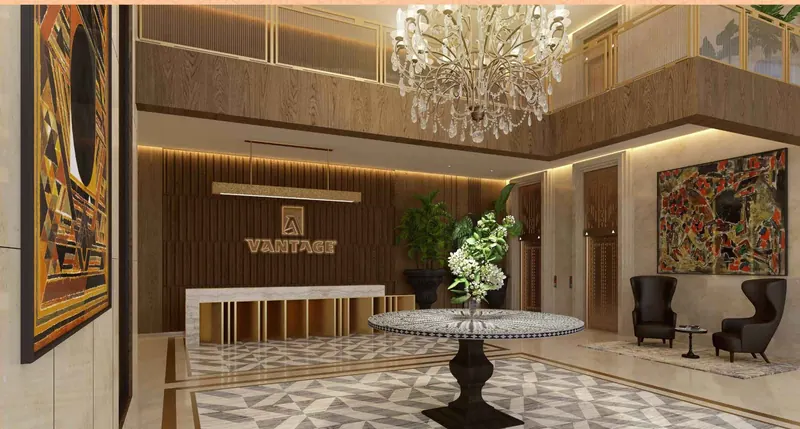 Double-height clubhouse lobby with a chandelier at Sri Aditya Vantage